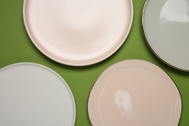 Photo of Beautiful ceramic plates on green background, top view