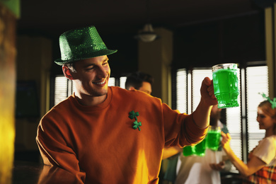 Photo of Man with glass of green beer in pub. St. Patrick's Day celebration