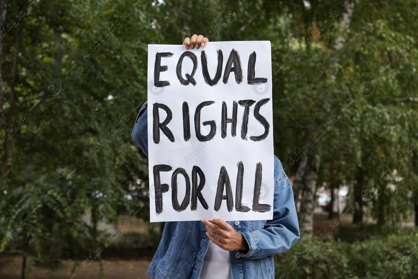 Photo of Woman holding sign with text Equal rights for all outdoors