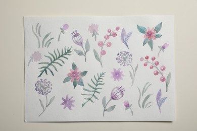 Sheet of paper with floral watercolor pattern on light background, top view