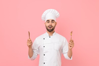 Photo of Professional chef holding kitchen utensils on pink background