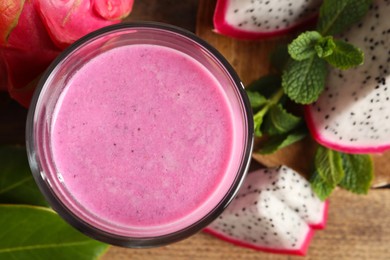 Delicious pitahaya smoothie and fresh fruits on table, flat lay