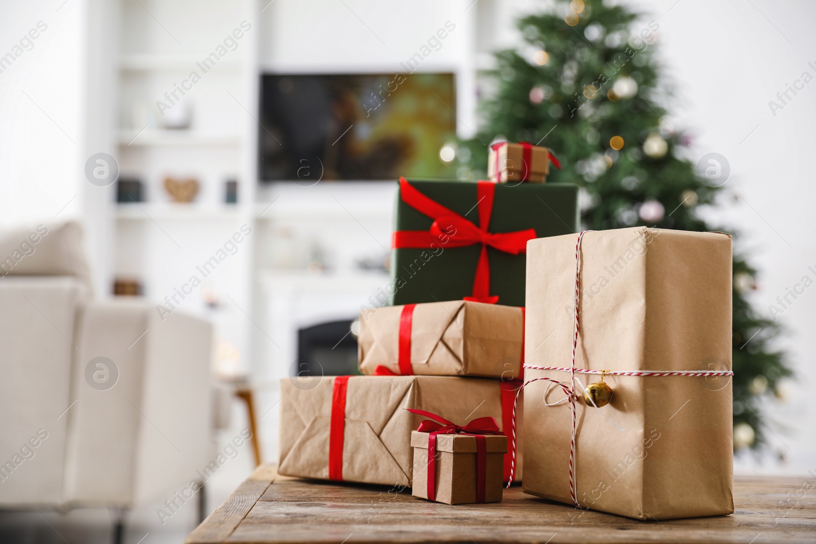 Photo of Beautifully wrapped Christmas gifts on wooden table indoors, space for text