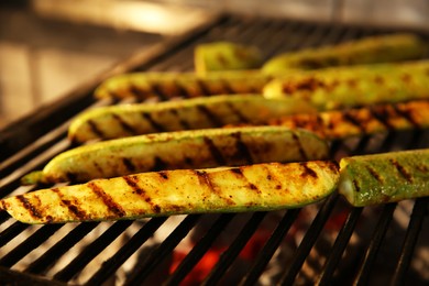 Photo of Cooking delicious fresh zucchini on grilling grate in oven, closeup