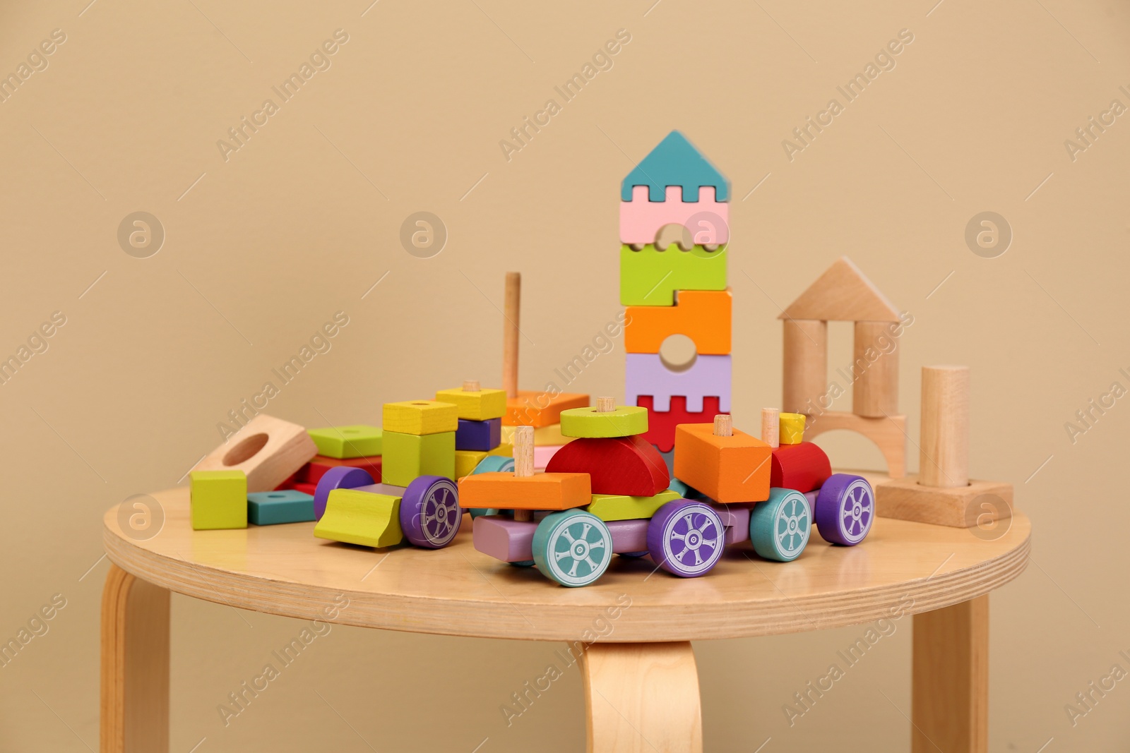 Photo of Set of different wooden toys on table against beige background