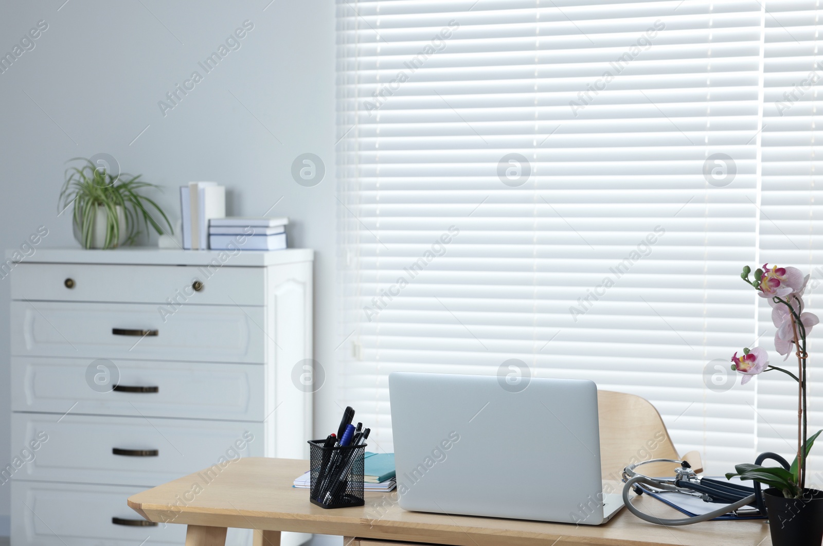 Photo of Modern clinic interior with wooden furniture and laptop