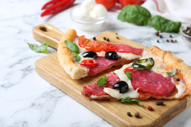 Photo of Composition with pieces of delicious pizza Diablo and ingredients on white marble table, closeup