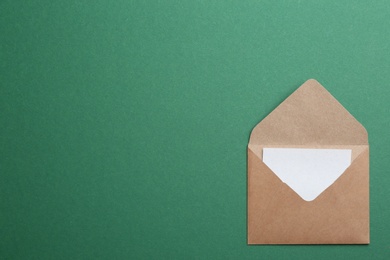 Photo of Brown paper envelope on green background, top view. Space for text