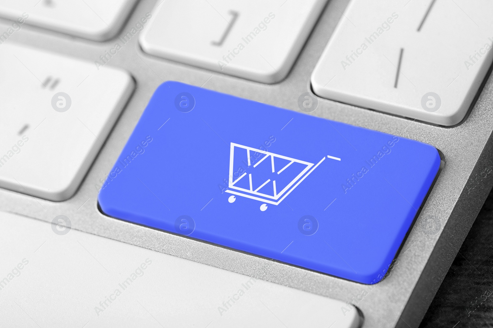 Image of Online store. Blue button with shopping cart on computer keyboard, closeup