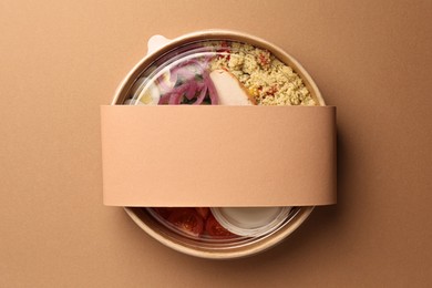 Tasty food in container on beige background, top view. Space for text