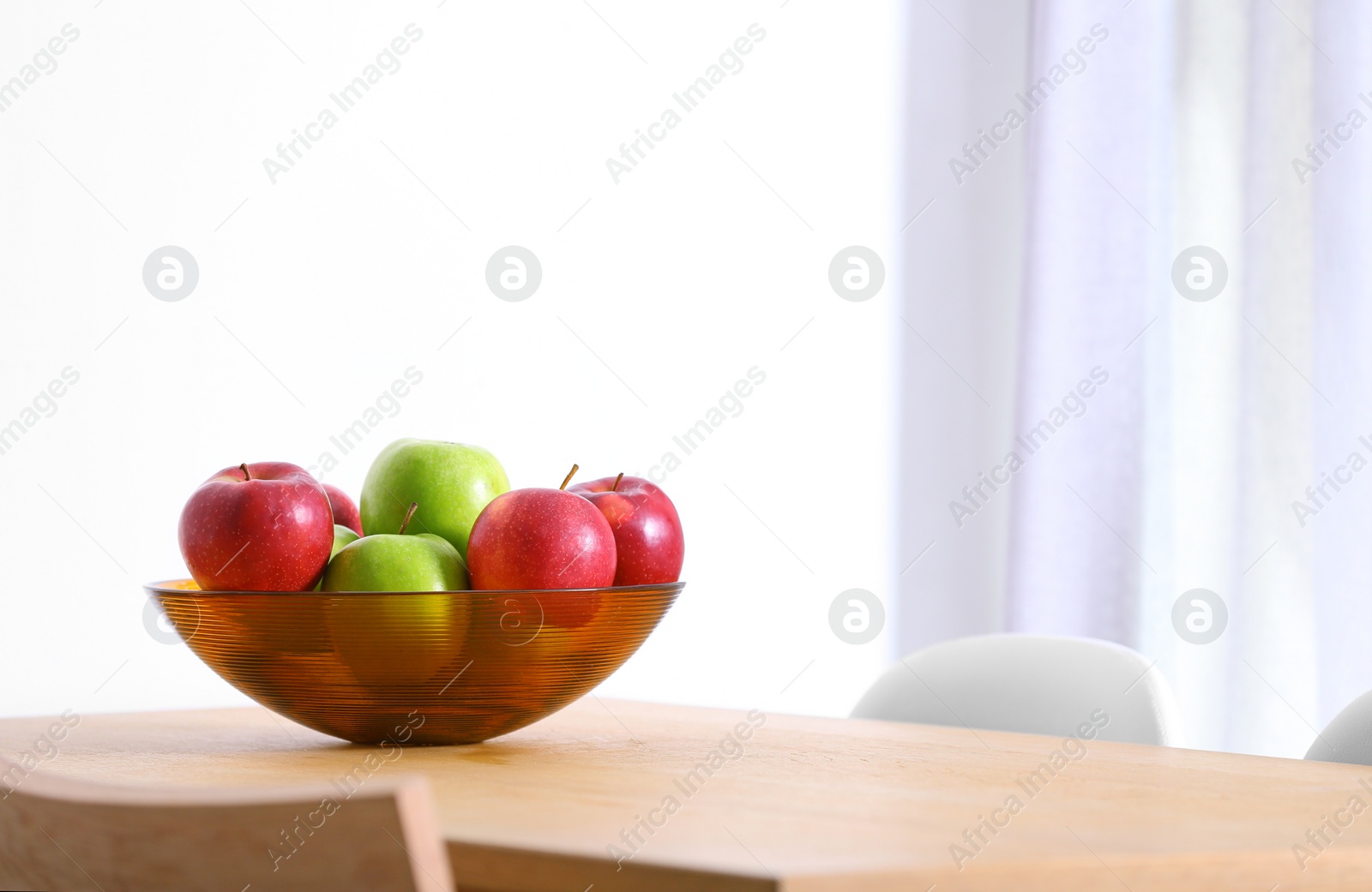 Photo of Bowl of fresh apples on table indoors. Space for text