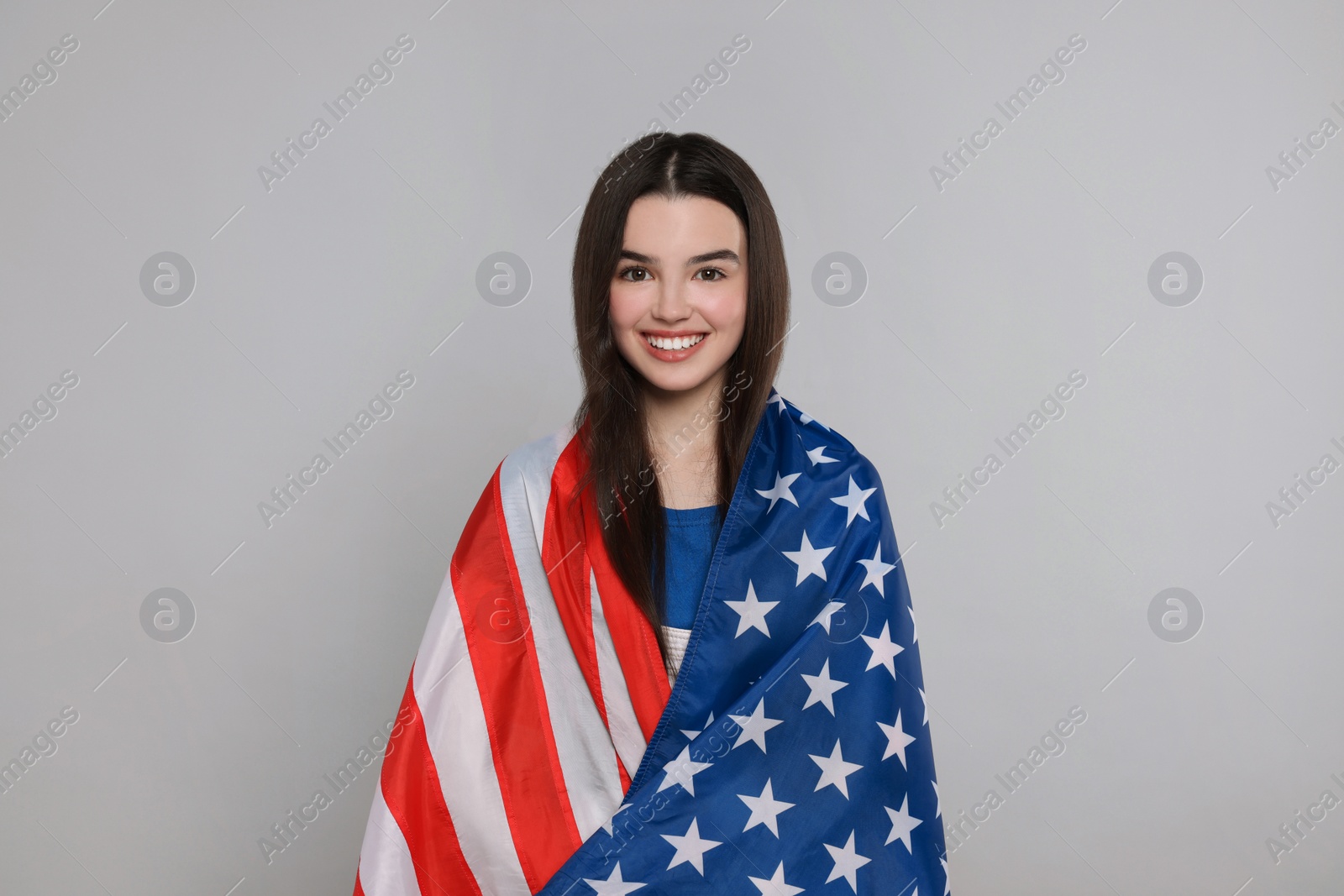 Photo of 4th of July - Independence Day of USA. Happy girl with American flag on grey background