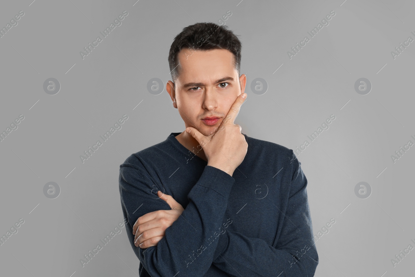 Photo of Portrait of thoughtful young man on grey background