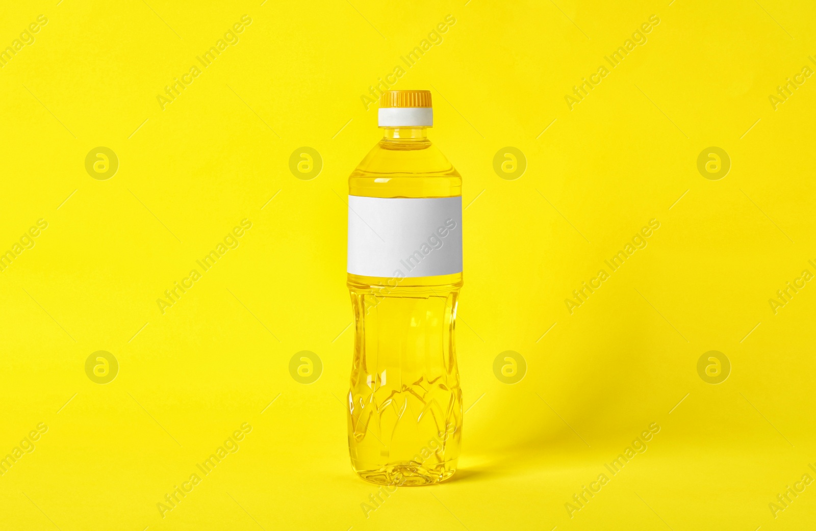 Photo of Bottle of cooking oil on yellow background