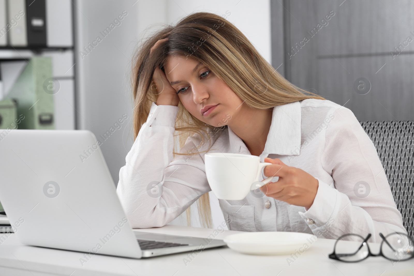 Photo of Sleepy young woman at workplace in office