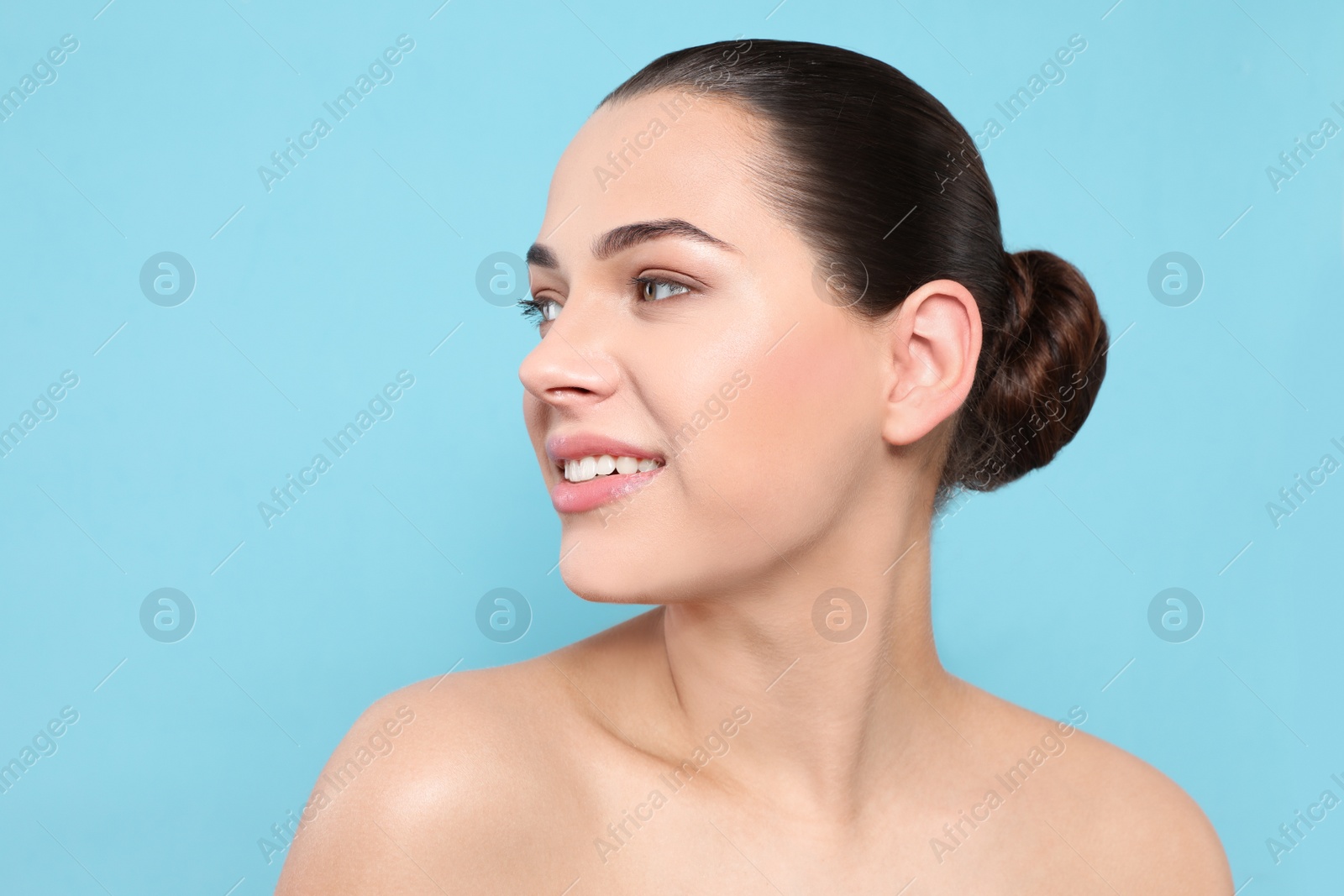 Photo of Portrait of young woman with beautiful face and natural makeup on color background