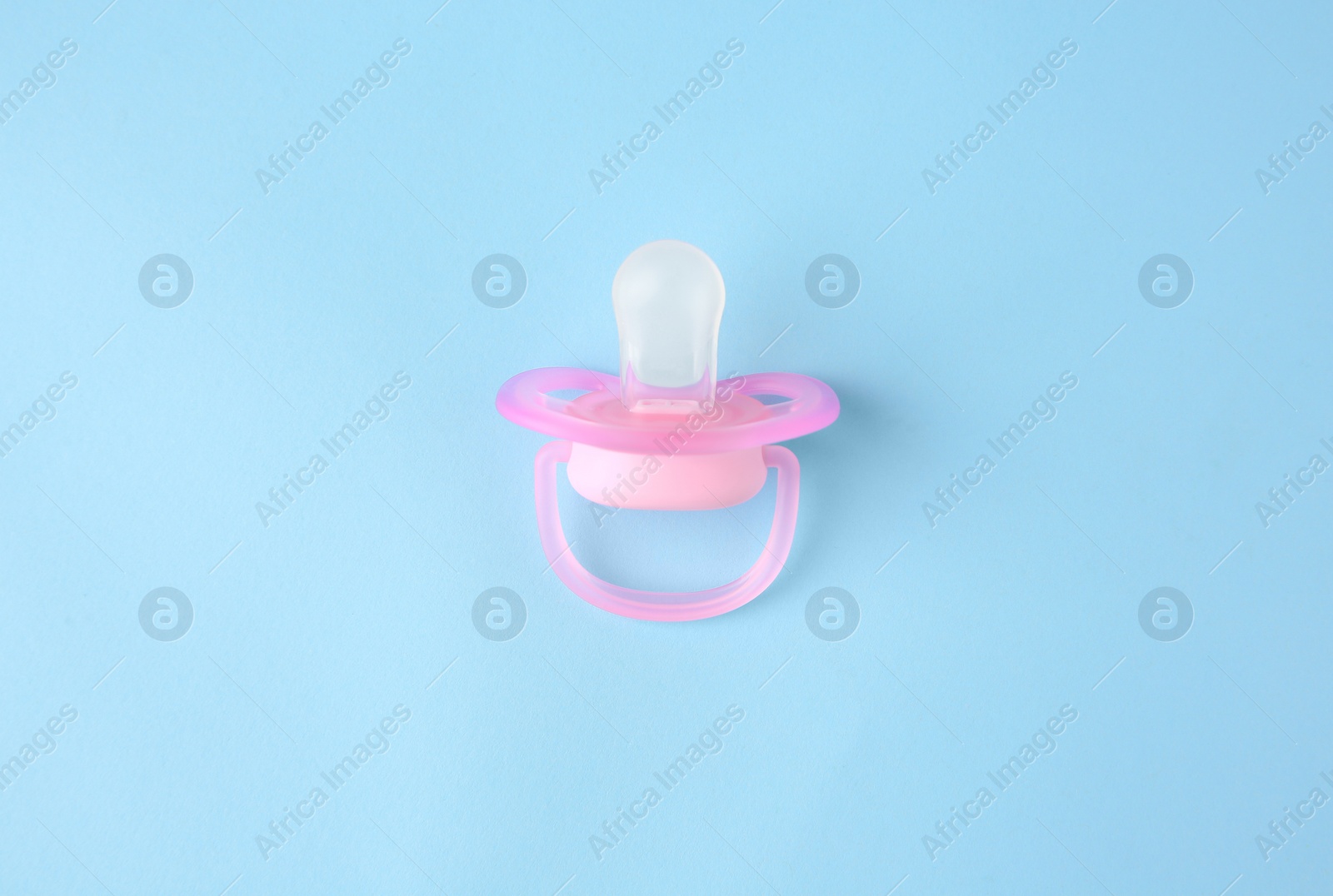 Photo of One new baby pacifier on light blue background, top view