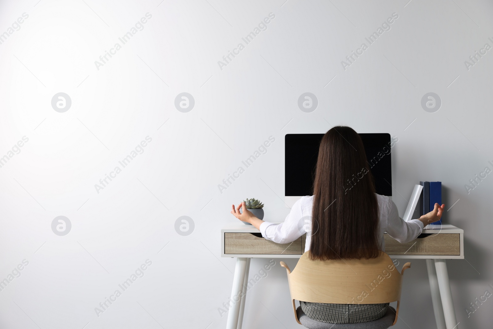 Photo of Find zen. Woman taking break from work at table indoors, back view. Space for text