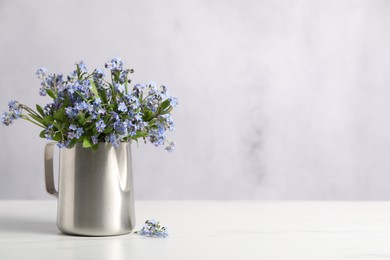 Beautiful forget-me-not flowers on white table. Space for text