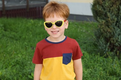 Photo of Cute little boy with sunglasses in park