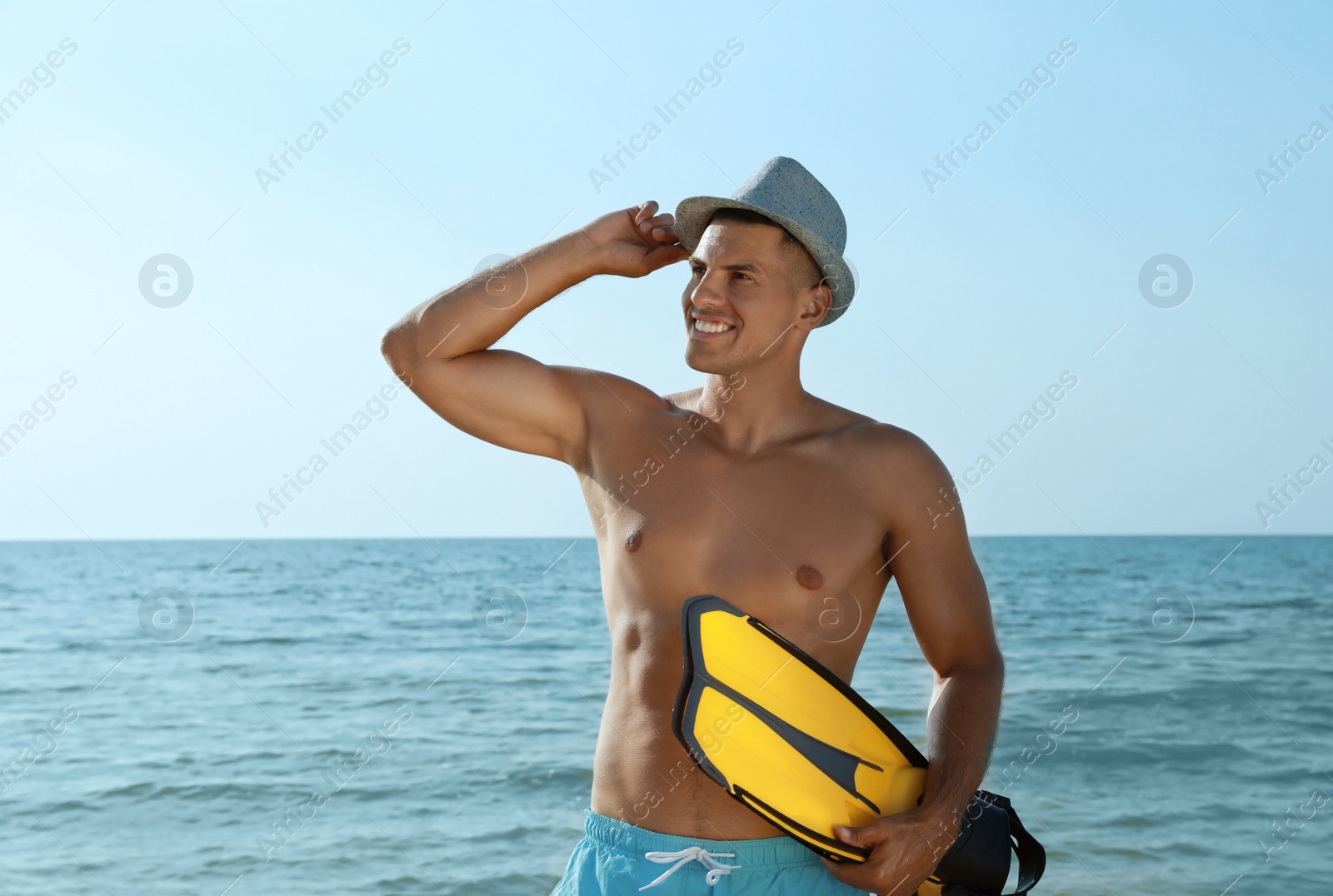 Photo of Happy man with flippers near sea on beach