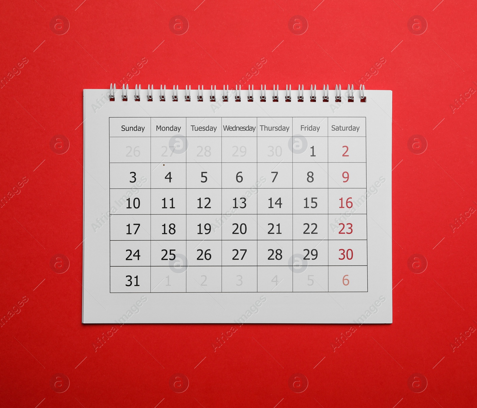 Photo of Paper calendar on red background, top view