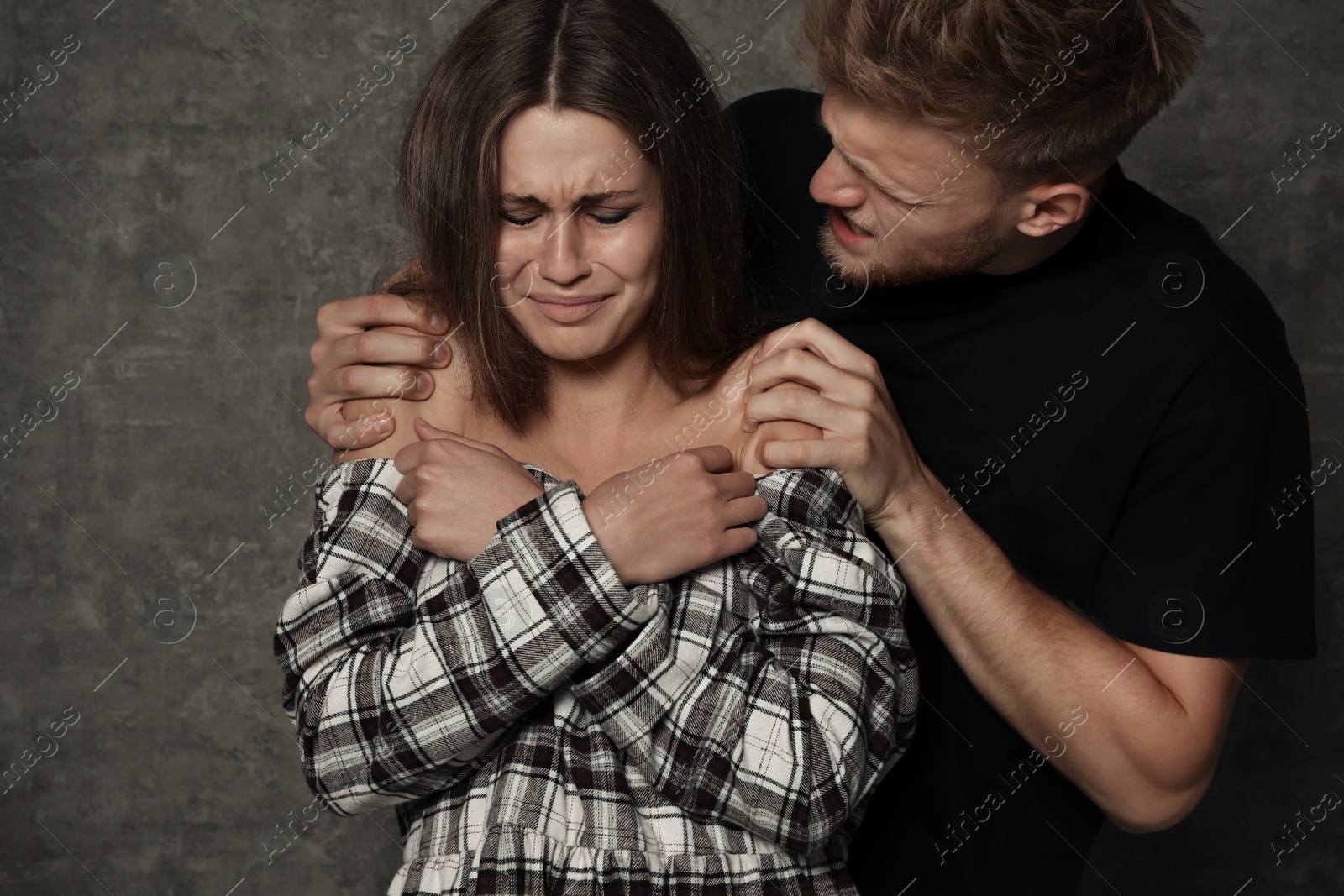Photo of Man abusing young woman on grey background. Stop sexual assault