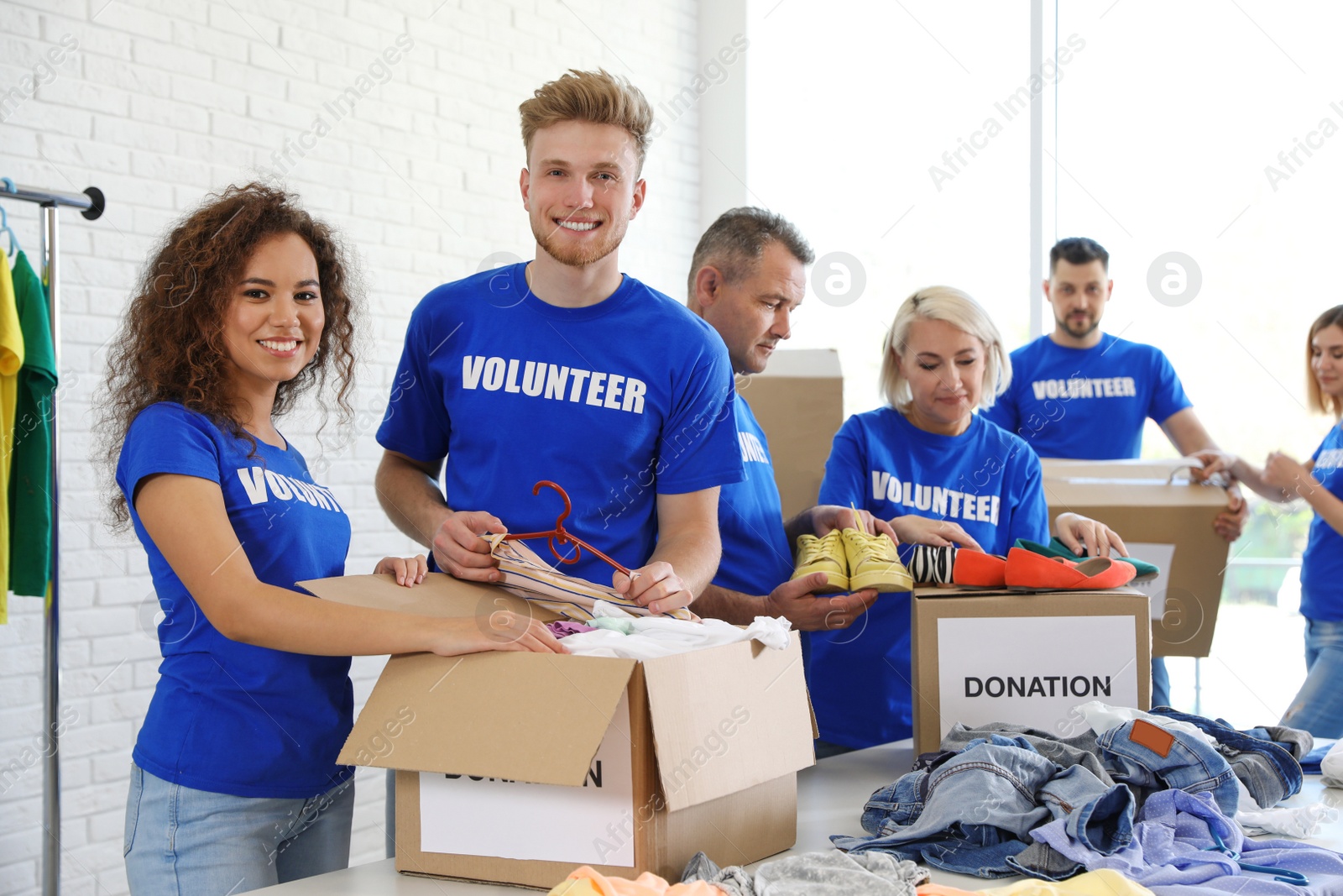 Photo of Team of volunteers collecting donations in boxes indoors