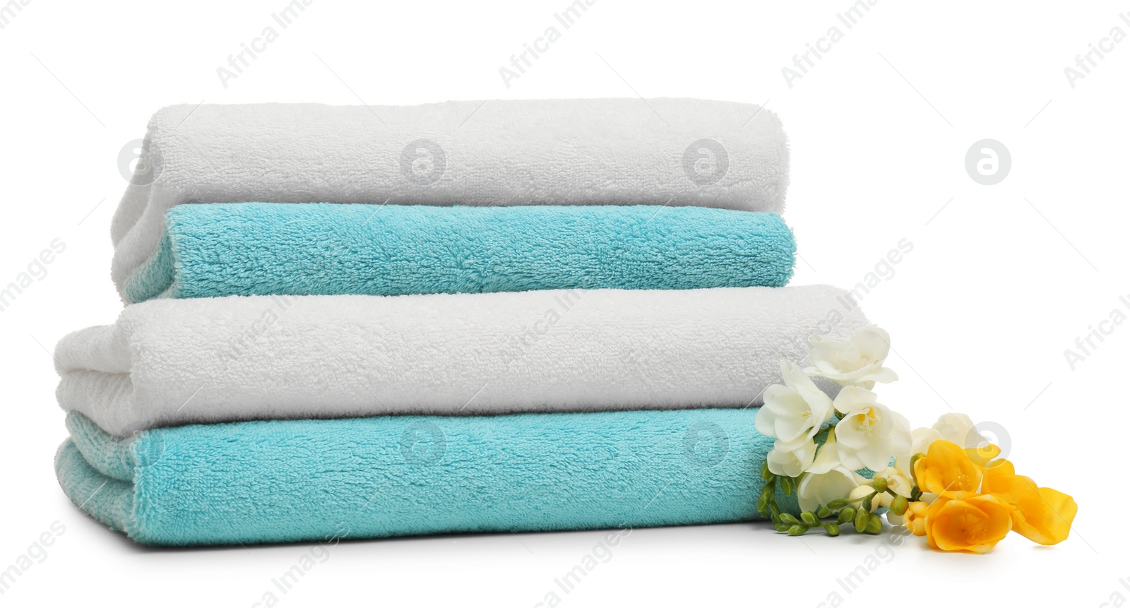 Photo of Stack of clean folded towels with flowers on white background