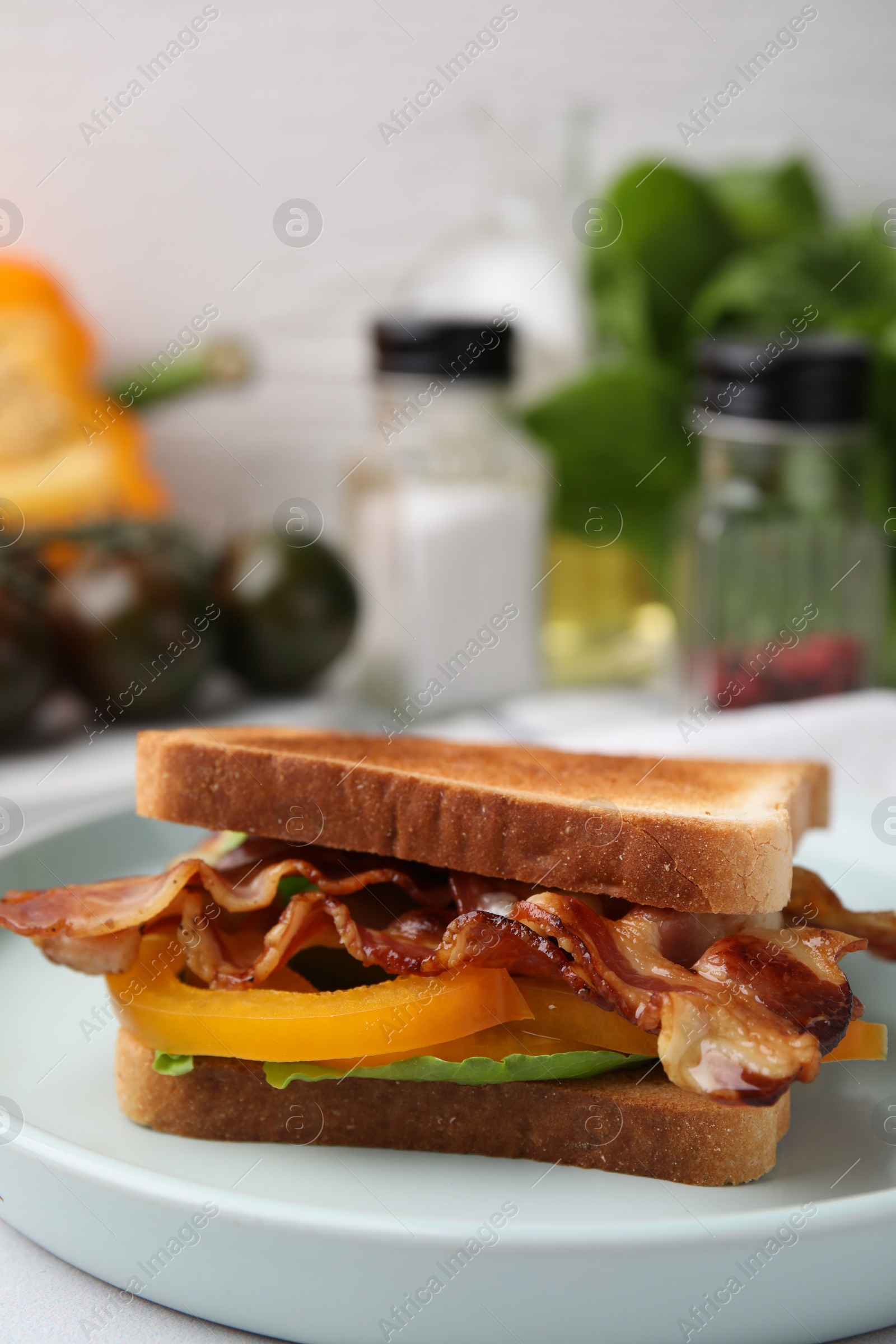 Photo of Tasty sandwich with bacon and bell pepper on white table, closeup