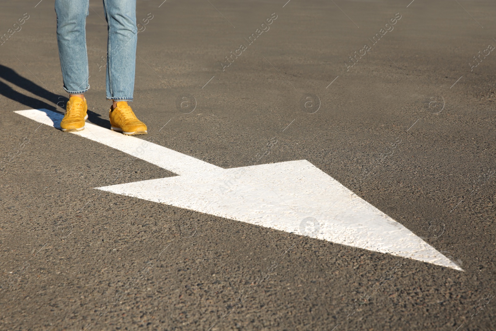 Photo of Woman going along road with arrow marking, closeup