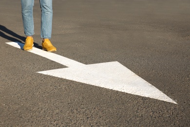 Photo of Woman going along road with arrow marking, closeup