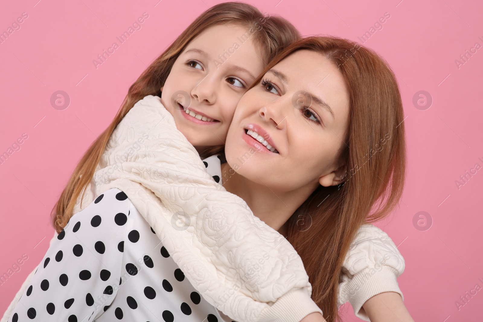 Photo of Portrait of happy mother and her cute daughter on pink background