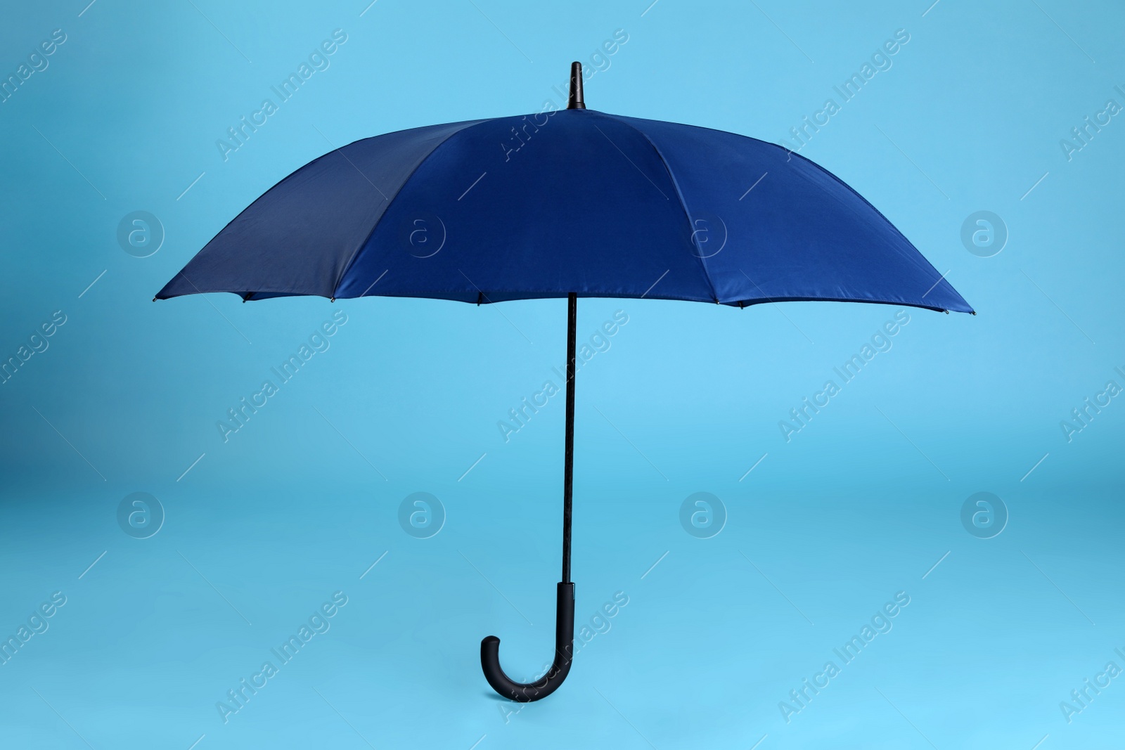 Photo of Stylish open bright umbrella on light blue background