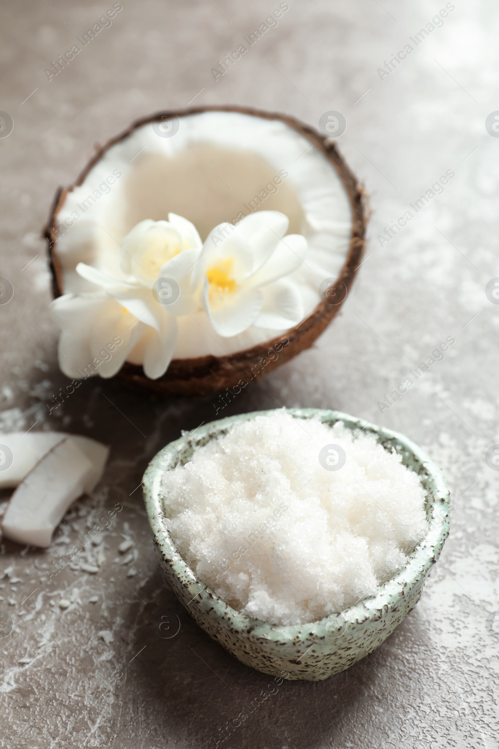 Photo of Bowl with natural coconut scrub on grey background