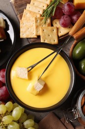 Tasty cheese fondue and snacks on grey table, flat lay