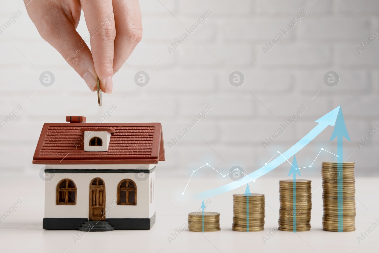 Image of Mortgage rate. Woman putting coin into house shaped money box, closeup. Stacked coins, graph and arrows