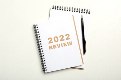 Image of Text 2022 Review written in notebook and pen on white background, top view