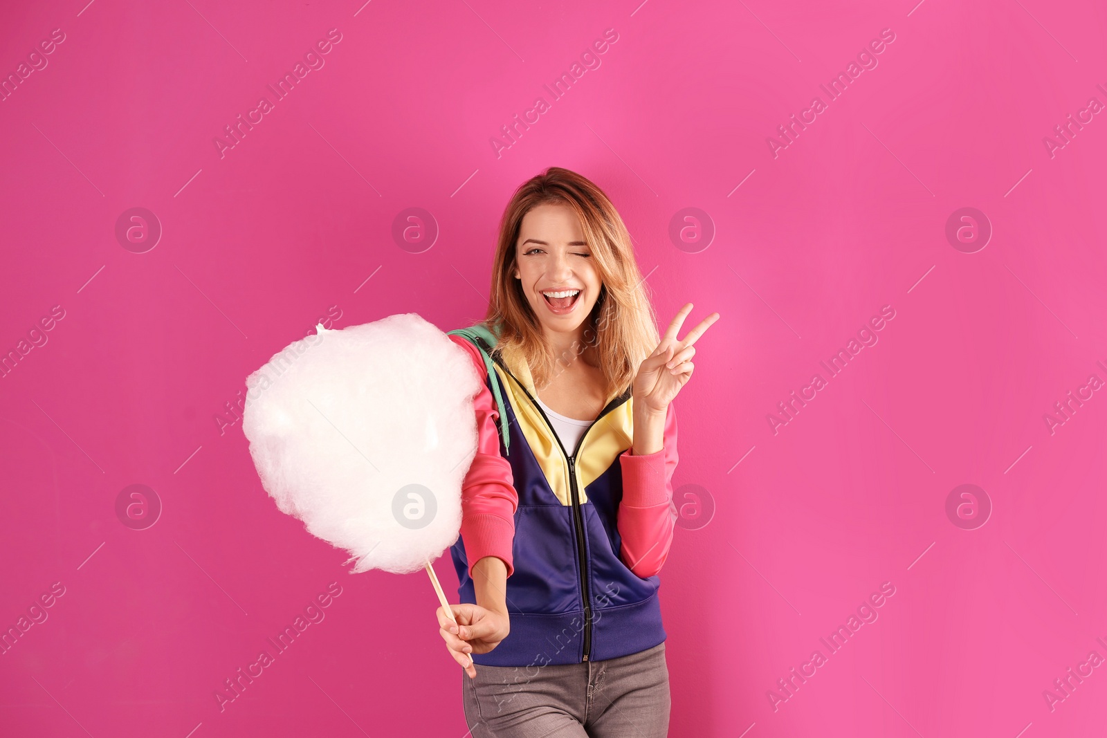 Photo of Young pretty woman with cotton candy on colorful background