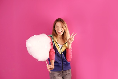 Photo of Young pretty woman with cotton candy on colorful background