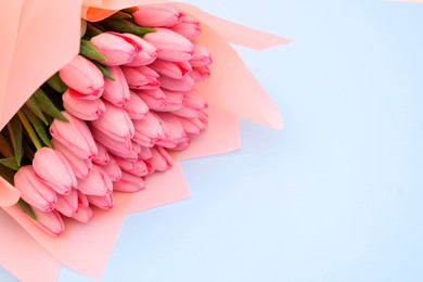 Bouquet of beautiful pink tulips on light grey background, above view. Space for text