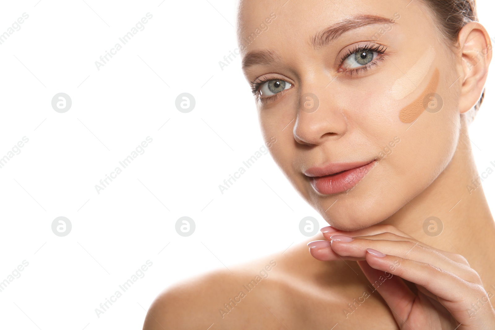 Photo of Young woman with different shades of skin foundation on her face against white background