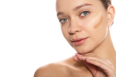 Young woman with different shades of skin foundation on her face against white background