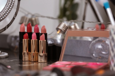 Photo of Different lipsticks on dressing table in makeup room