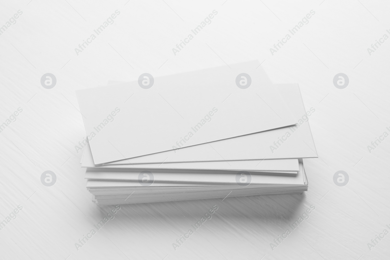 Photo of Stack of blank business cards on white table. Mockup for design