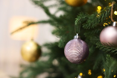 Photo of Beautiful Christmas balls hanging on fir tree, closeup. Space for text