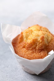 Photo of Delicious sweet muffin on grey textured table, closeup