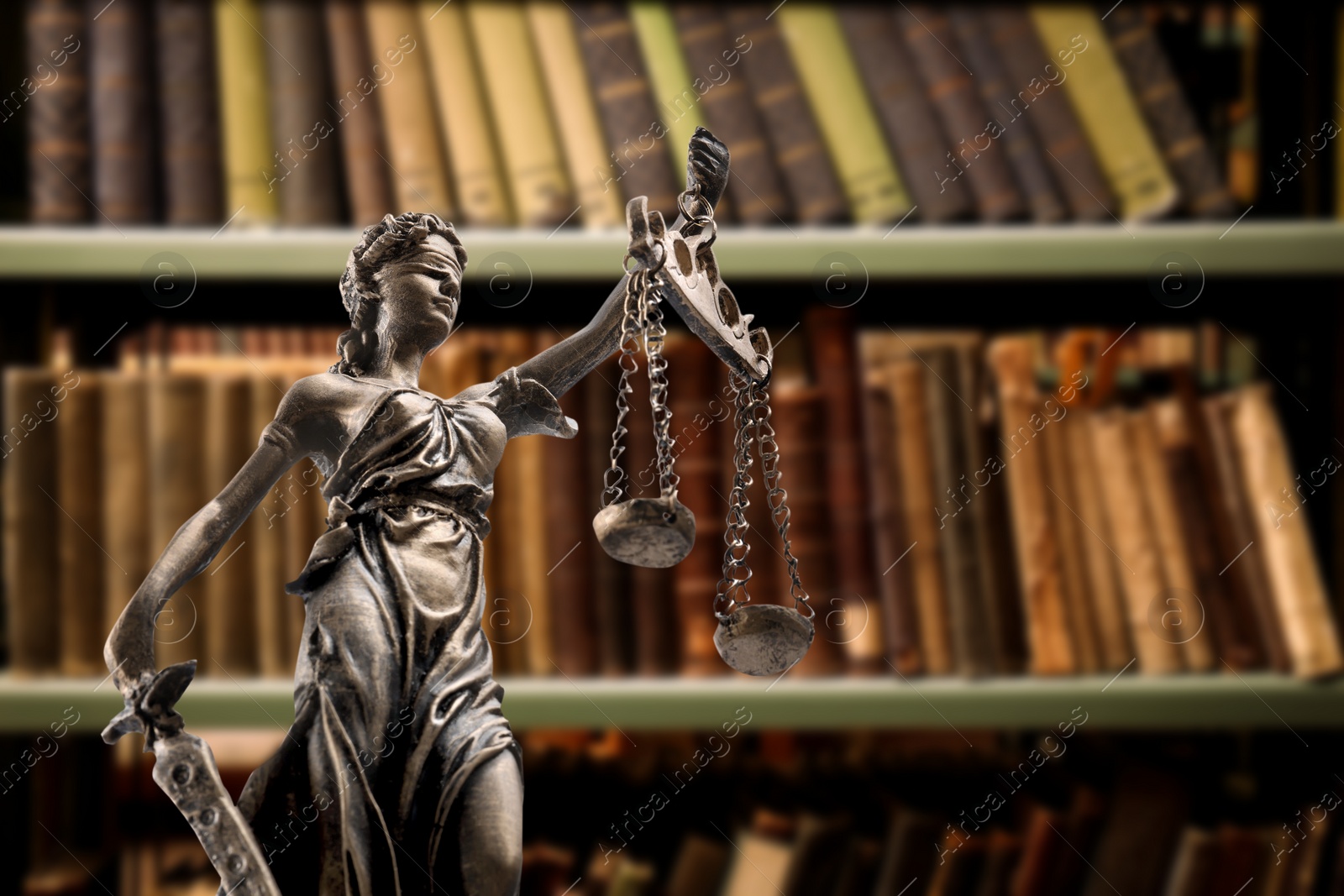 Image of Law and wisdom. Statue of Lady Justice near shelves with books, space for text