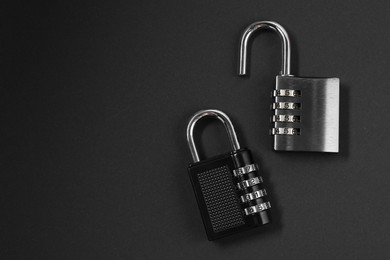 Photo of Steel combination padlocks on black background, top view. Space for text