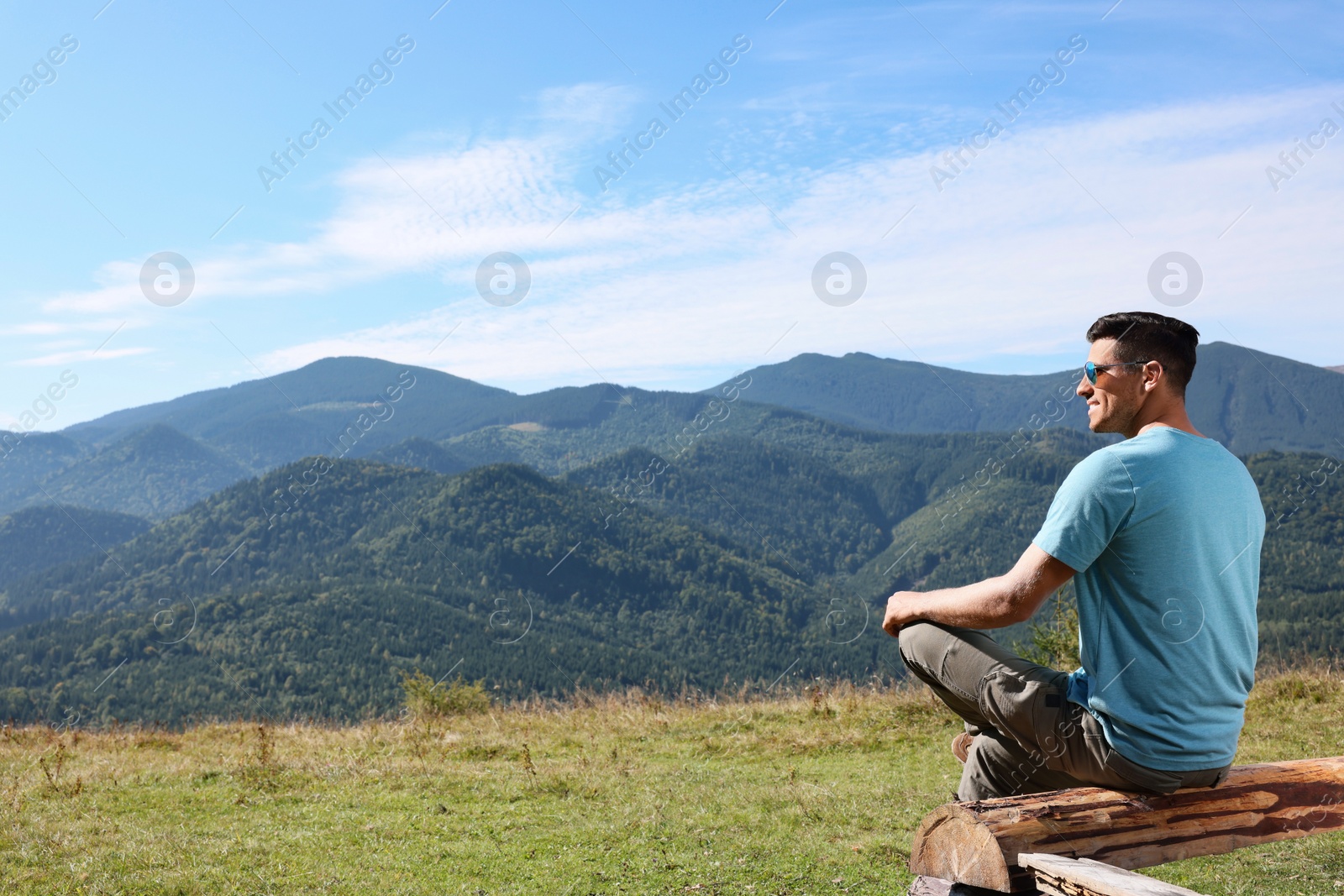 Photo of Man enjoying picturesque view of mountain landscape on sunny day